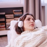 A woman listening to headphones looking depressed